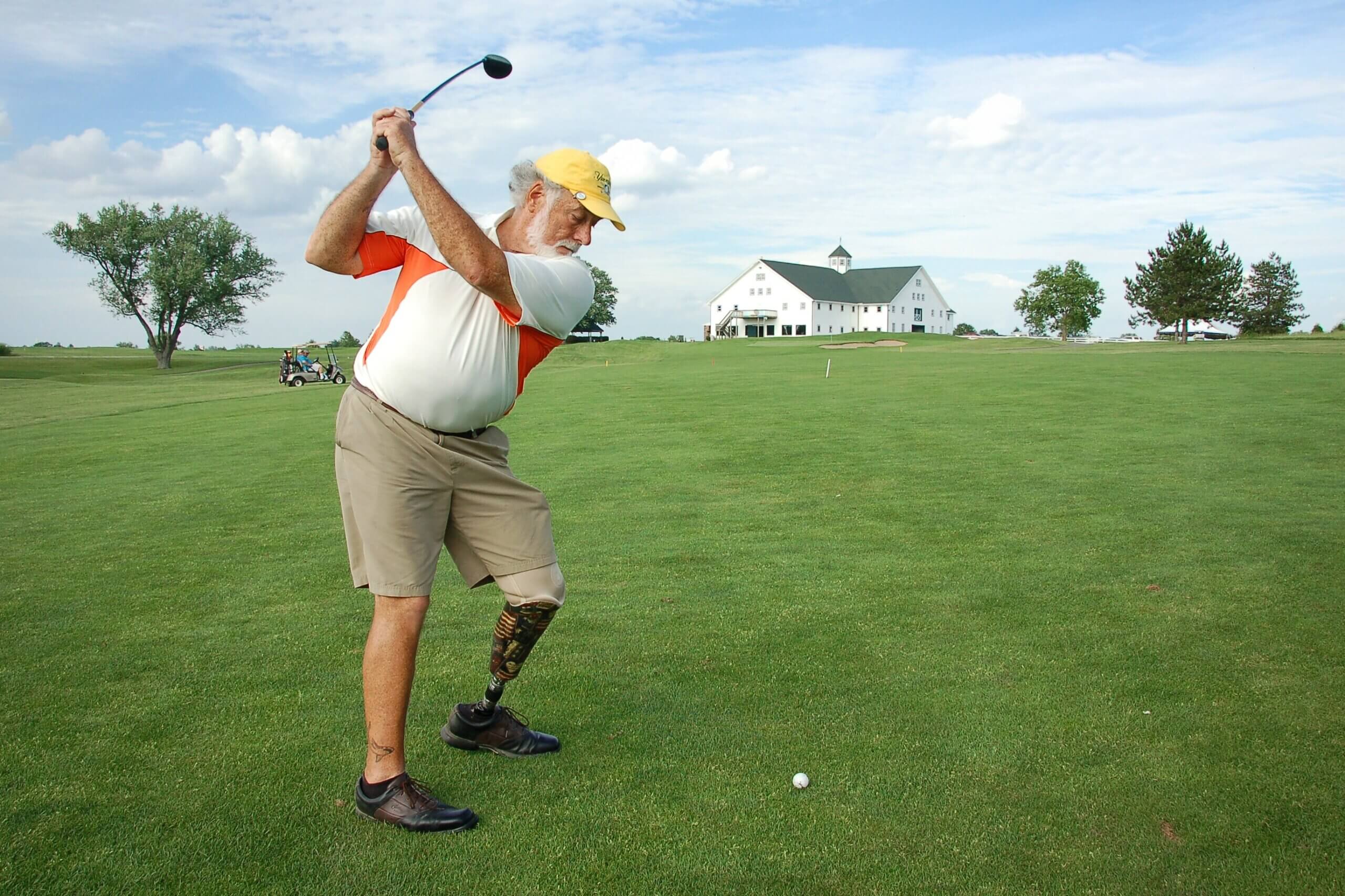 a man with a prosthetic leg swinging a golf club