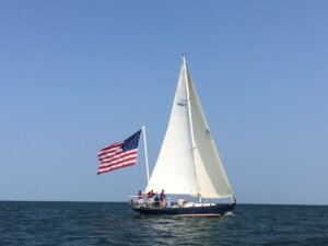 a ship called the Intrepid sailing the waters of Lake Erie flying a big American flag