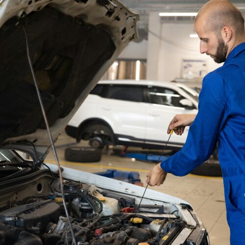 Car mechanic checking the oil level